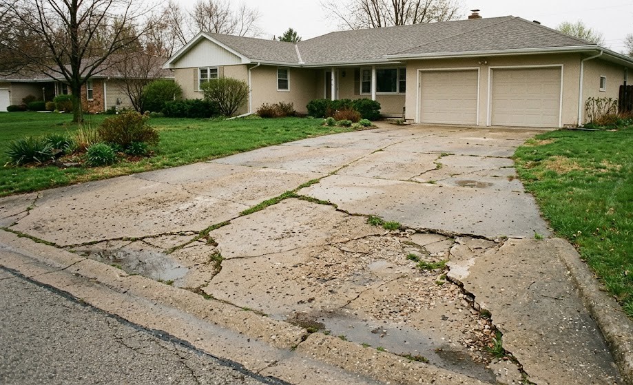Cracked and damaged concrete driveway needing repair in Washington County